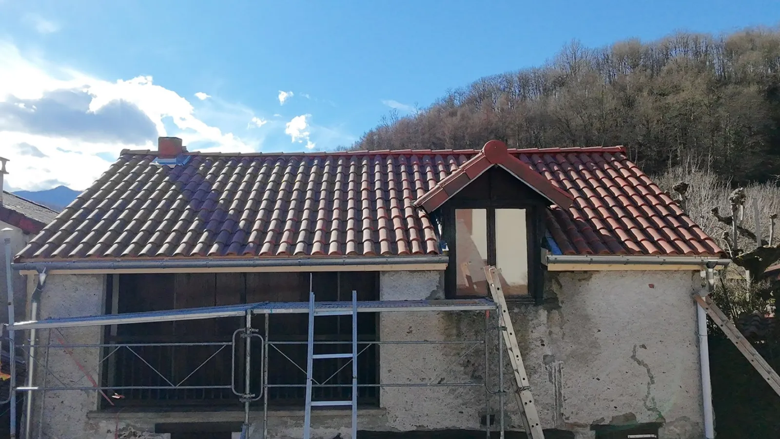 Maison avec lucarne après travaux : toiture refaite en tuiles neuves par Keller Rénovation Toiture