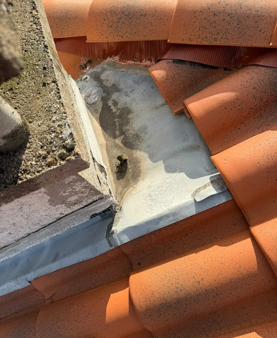 Abergement de cheminée en zinc façonné sur mesure sur une toiture en tuiles